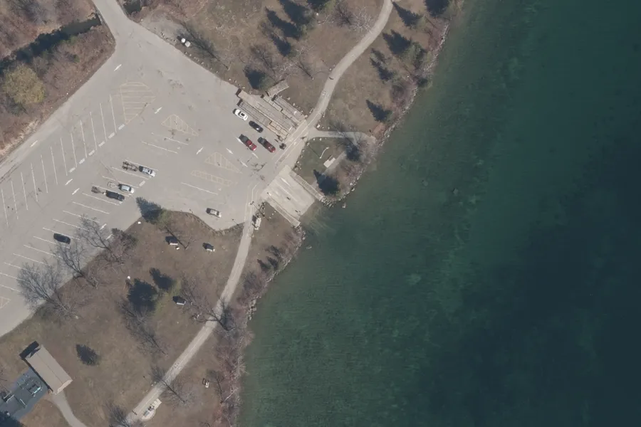 Aerial photograph of a boat launch ramp and its trailer parking beside Lake Simcoe