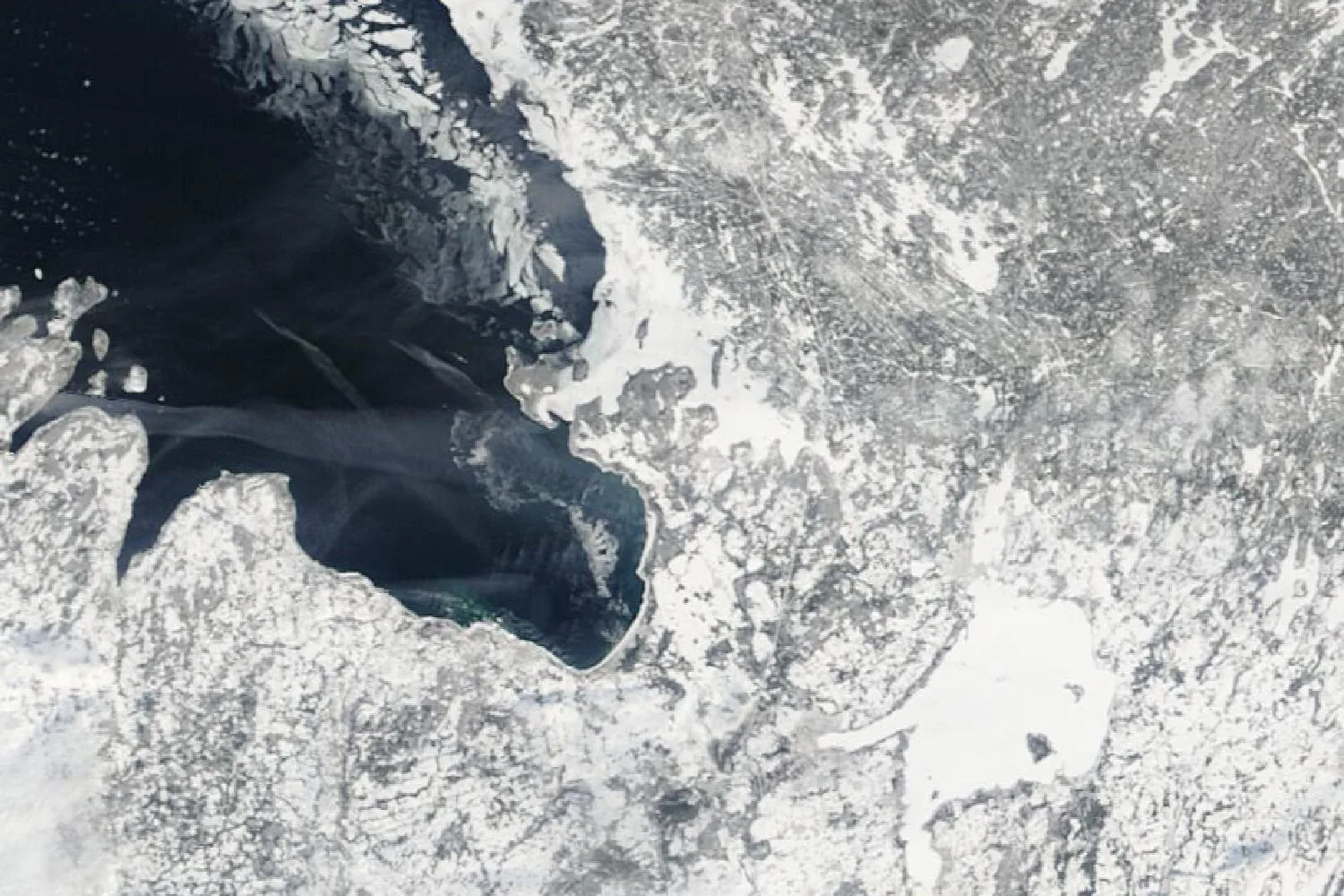 Satellite photograph of central Ontario in winter: the dark open water of Georgian Bay edged with ice floes, and Lake Simcoe frozen white