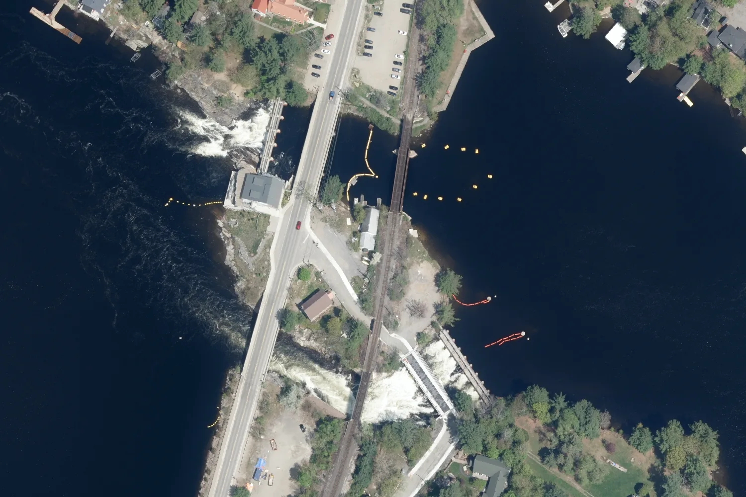 Aerial photograph of the two Bala dams on the Moon River at the outlet of Lake Muskoka, with the road and rail bridges crossing between them
